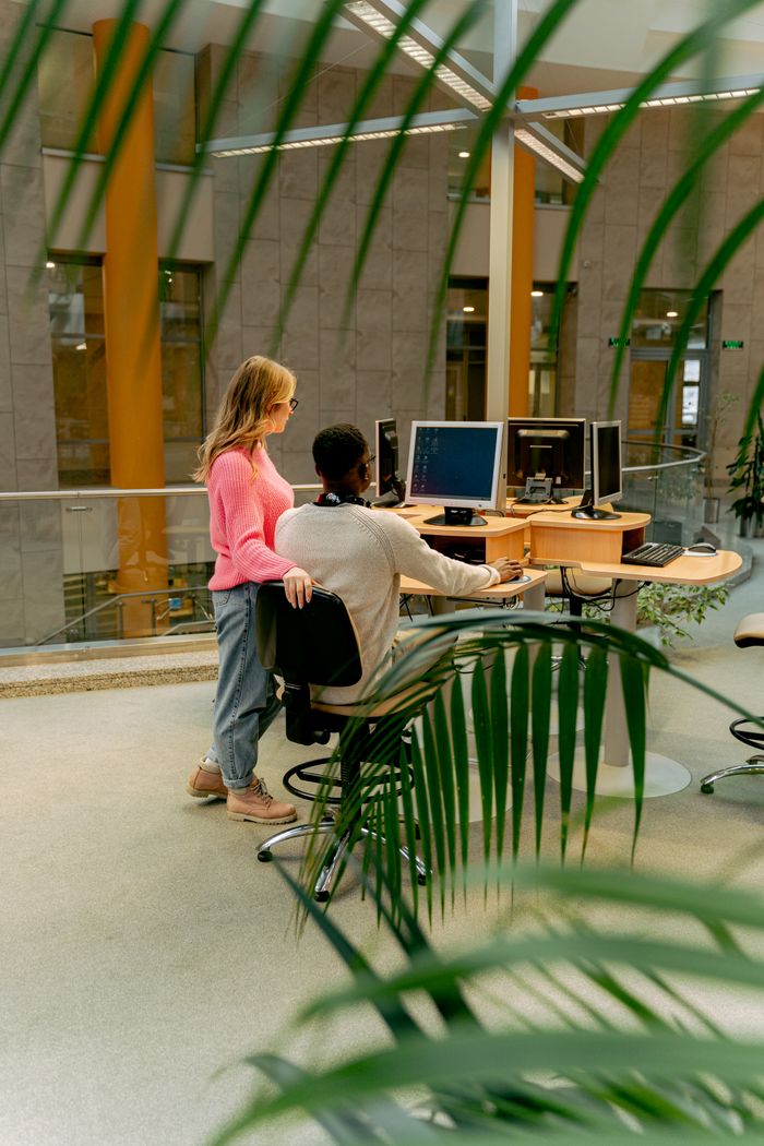 The Art of Drawing Readers In: Your attractive post title goes here Two colleagues working together in a bright and modern indoor office setting.